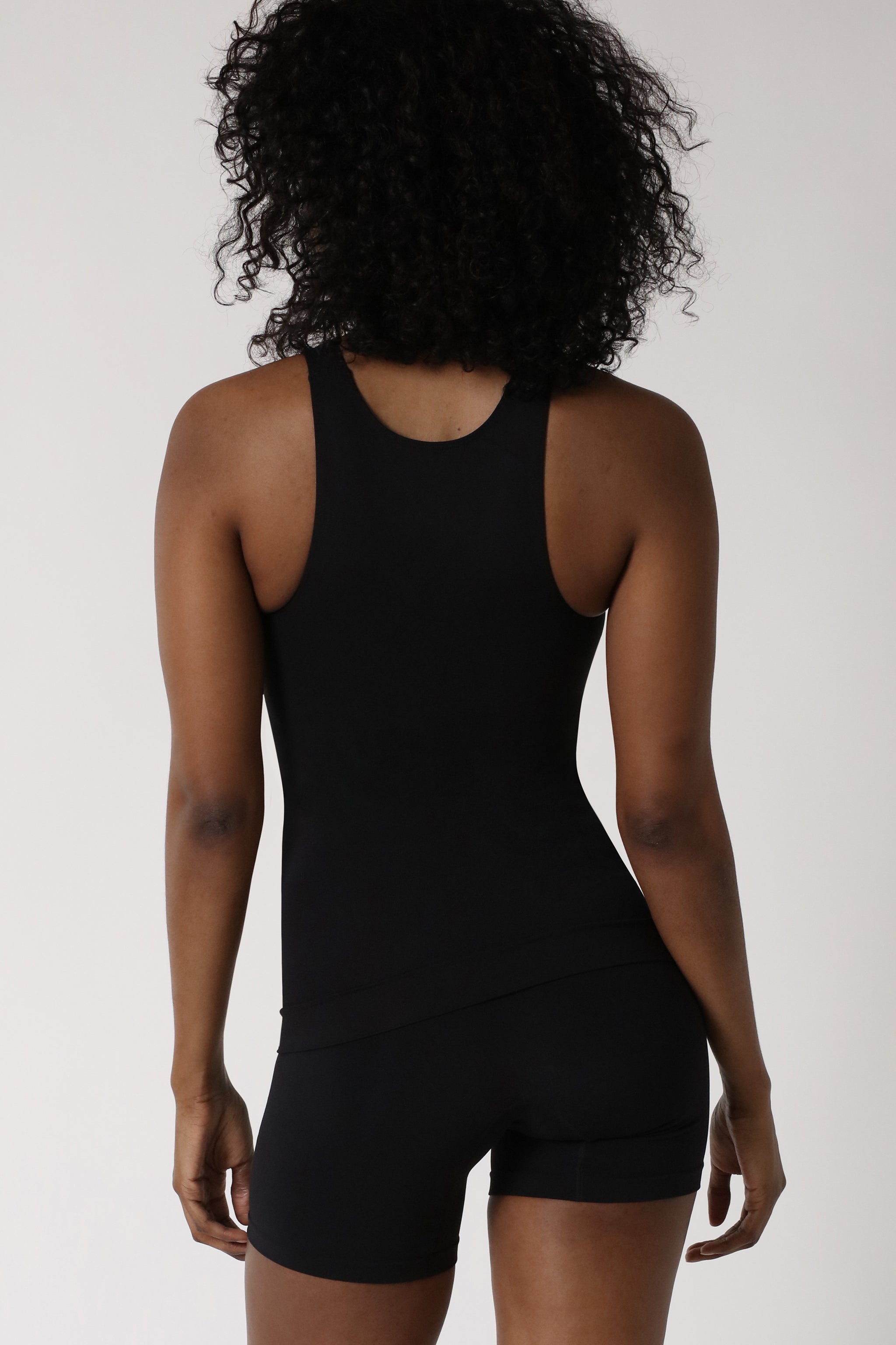 Shapewear Kollektion repräsentiert durch eine Dame, die ein schwarzes Miederhemd trägt - Schwarz