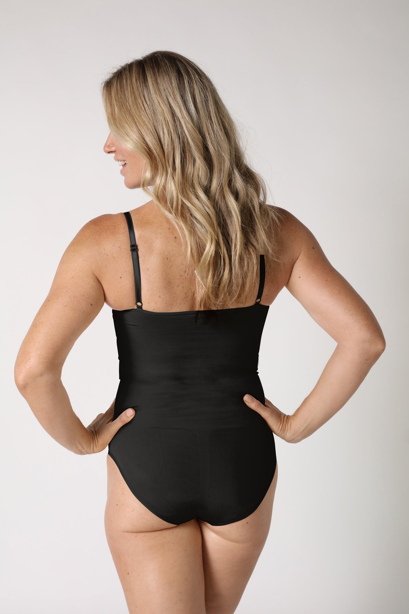 Dame trägt schwarzen Shapewear Body - Schwarz